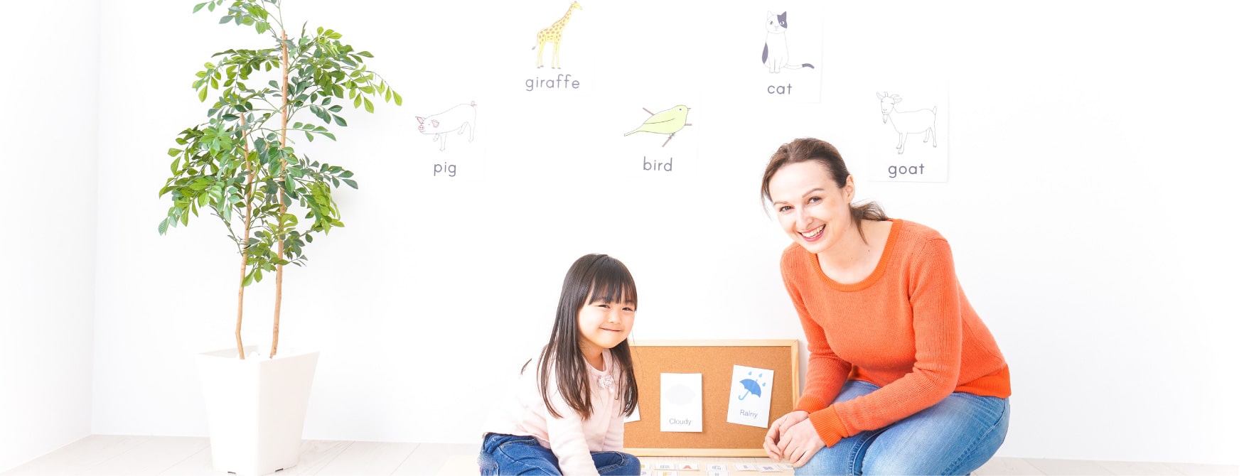 海外留学生の女性と女の子が笑顔で英語を学んでいる写真